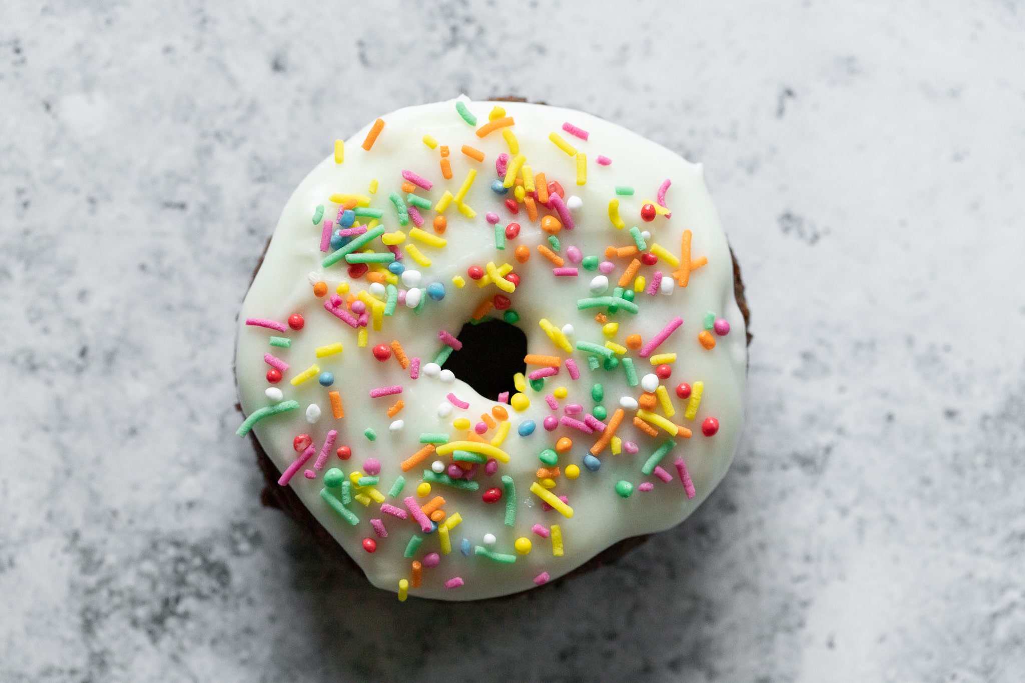 a funfetti old fashioned donut photographed from above