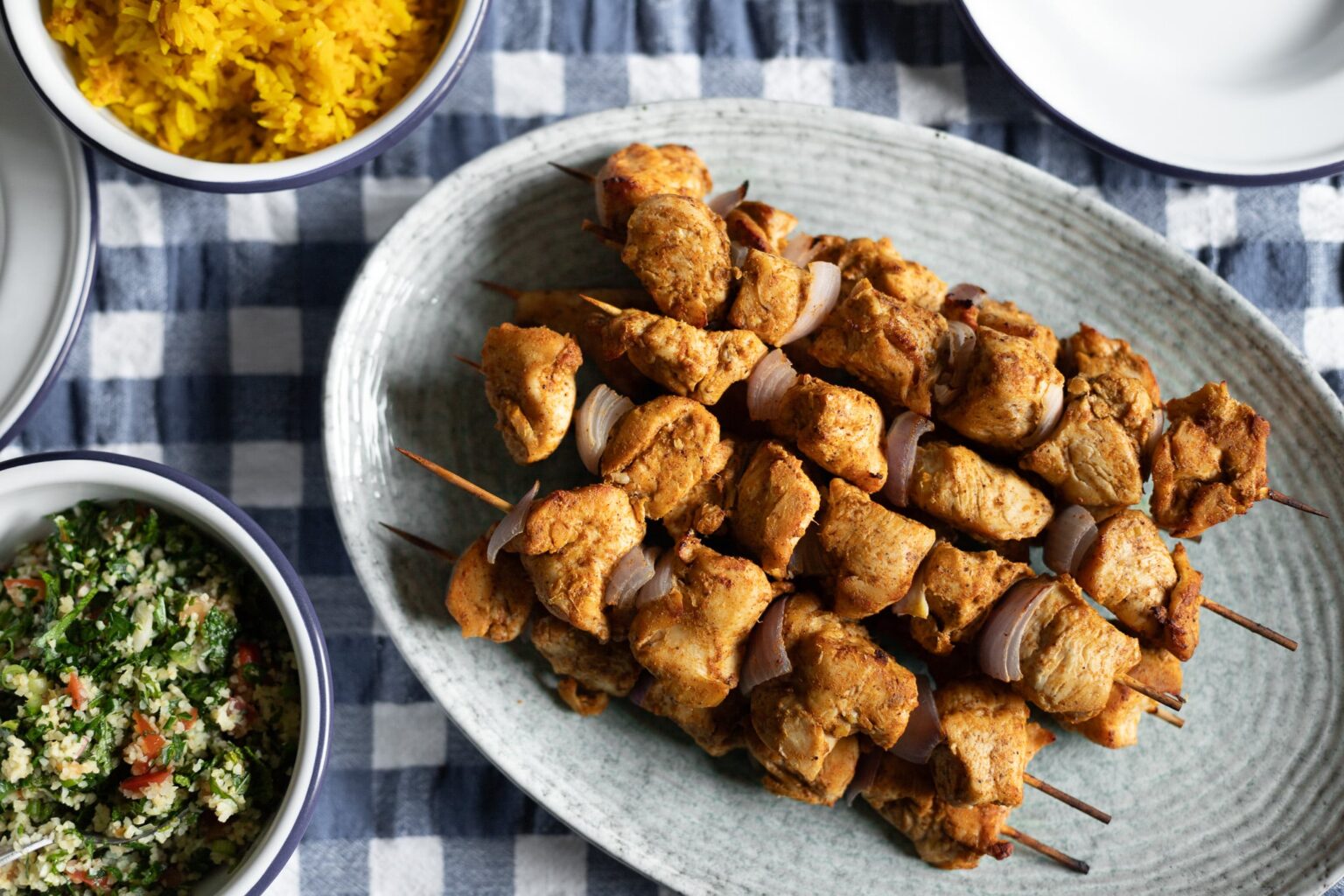 chicken kebabs on a blue gingham tablecloth