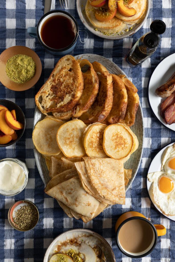 array of breakfast carbs on a blue gingham tablecloth with lots of toppings