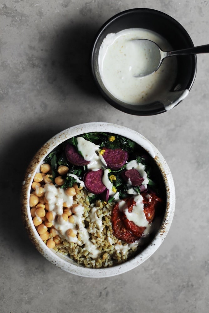 freekeh bowl with a bowl of tahini sauce next to it