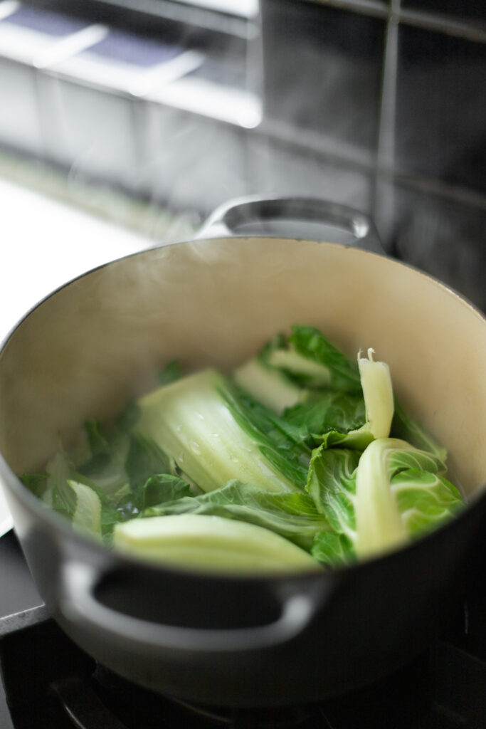 cauliflower leaves at the bottom of a pot