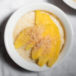coconut rice pudding with mango and coconut flakes